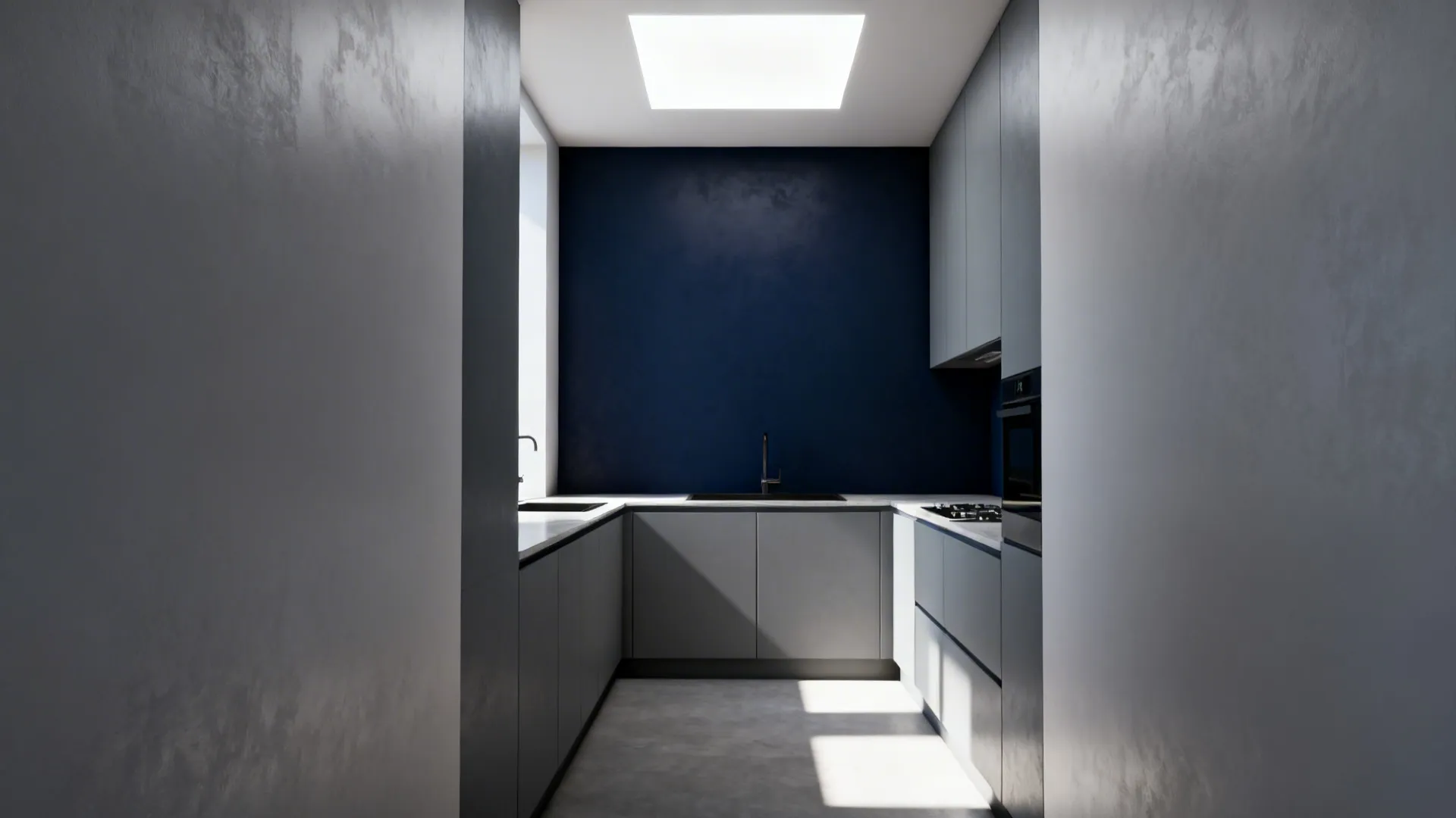 Narrow kitchen with a deep navy accent wall behind light gray cabinets and balanced lighting.