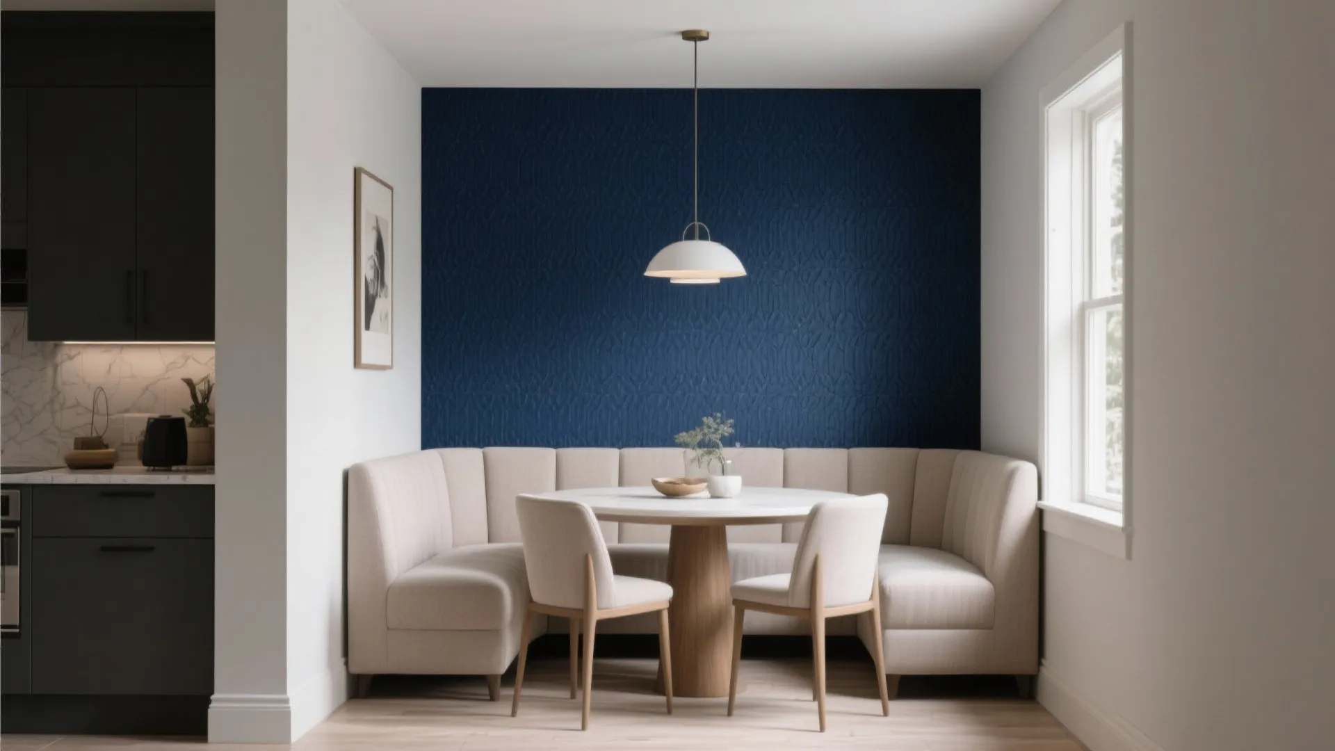 Dining area with navy blue wall curved white sofa round wooden table and ceiling light