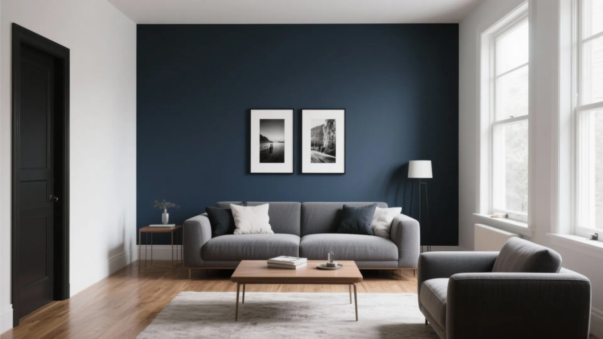Living room with grey sofa and navy blue wall featuring two framed black white photos