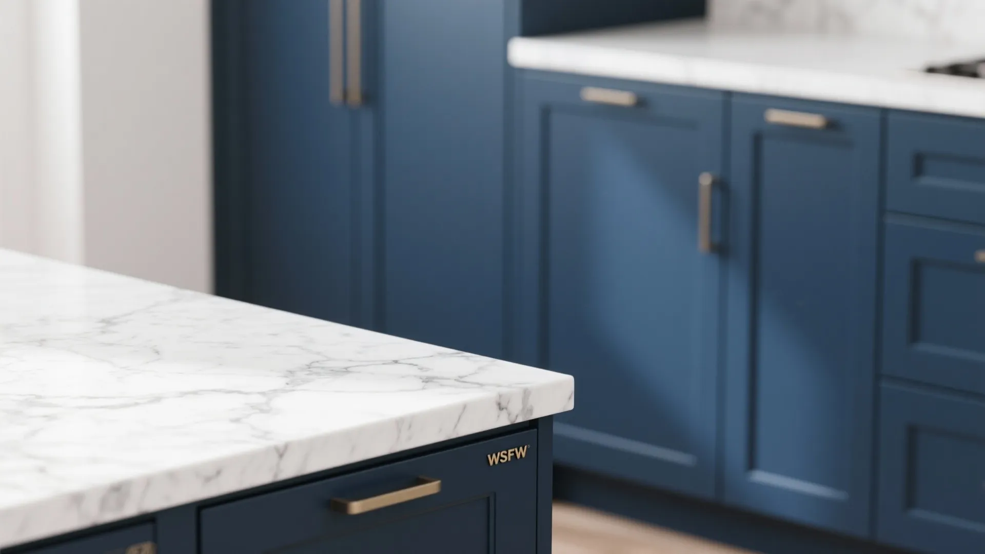 White marble countertop with grey veins on blue kitchen cabinets with modern gold metal handles