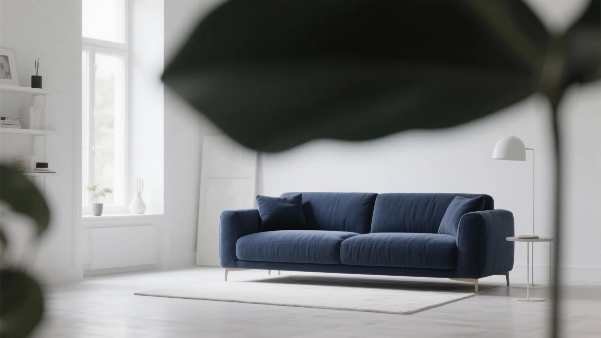 Deep navy sofa as focal point in white Scandinavian living room