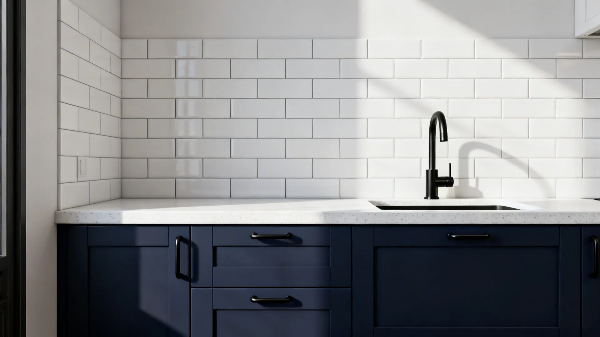 Compact kitchen with navy lowers, white stacked tile backsplash, and matte black accents.