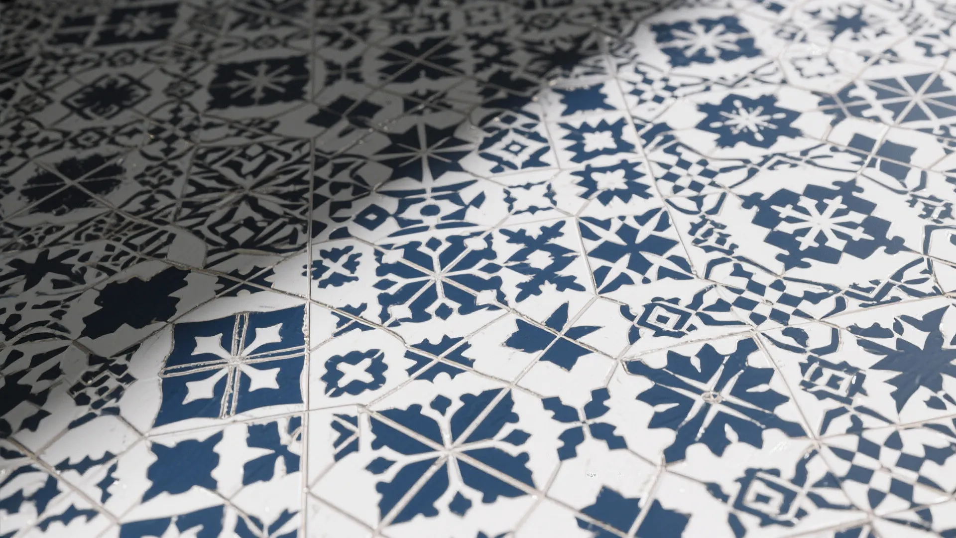 Close up view of navy blue and white patterned floor tiles with geometric flower designs