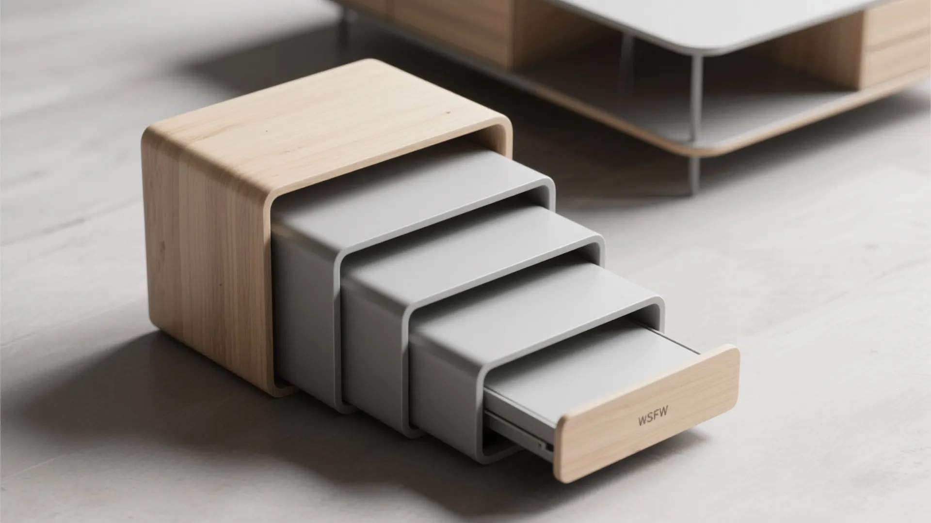 Modern set of four grey nesting tables with light wood frames on a grey floor