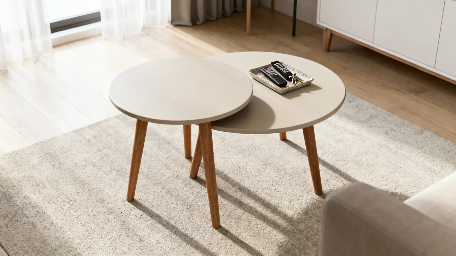 Nesting round side tables nested and extended in a tidy living room with a tray for small items
