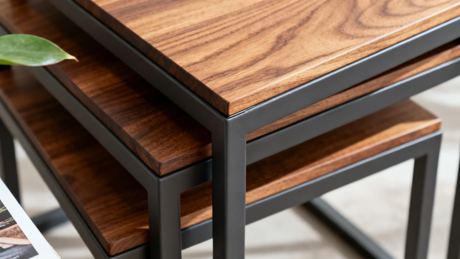 Macro detail of nesting side tables showing metal frame and wood top joinery.