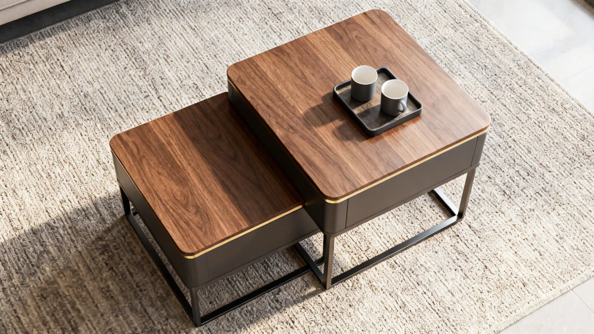 Two wooden nesting coffee tables on a grey rug with a tray holding two small cups