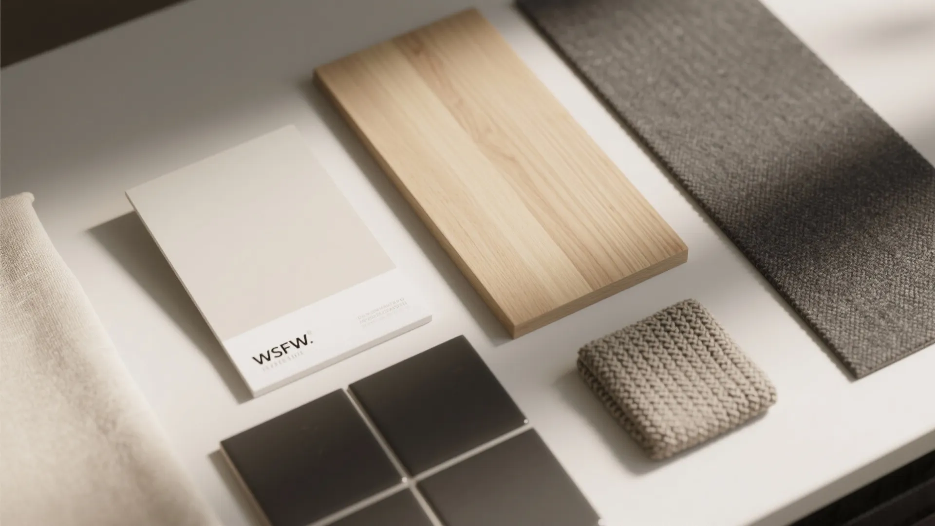 Material board with light wood samples grey fabric tiles and paint colors for interior design