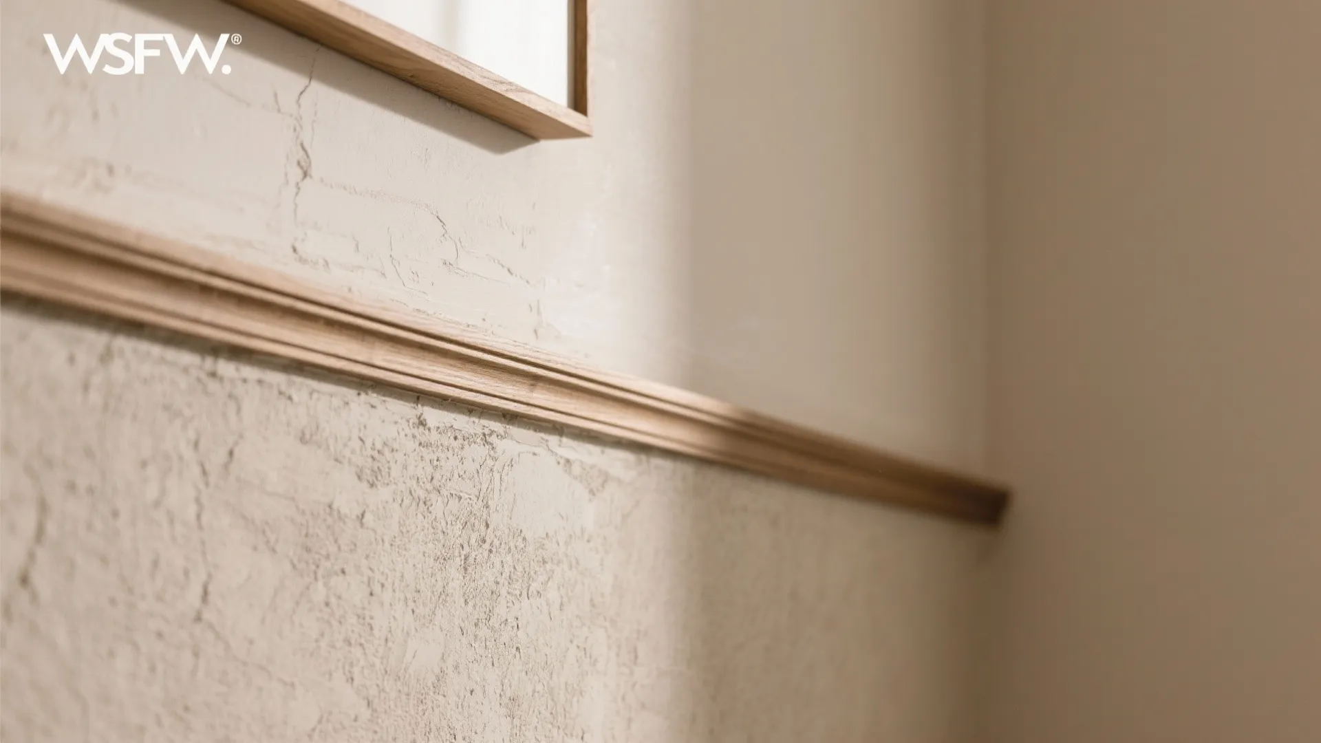 Close up of a textured wall with a wood wall panel and neutral beige colors