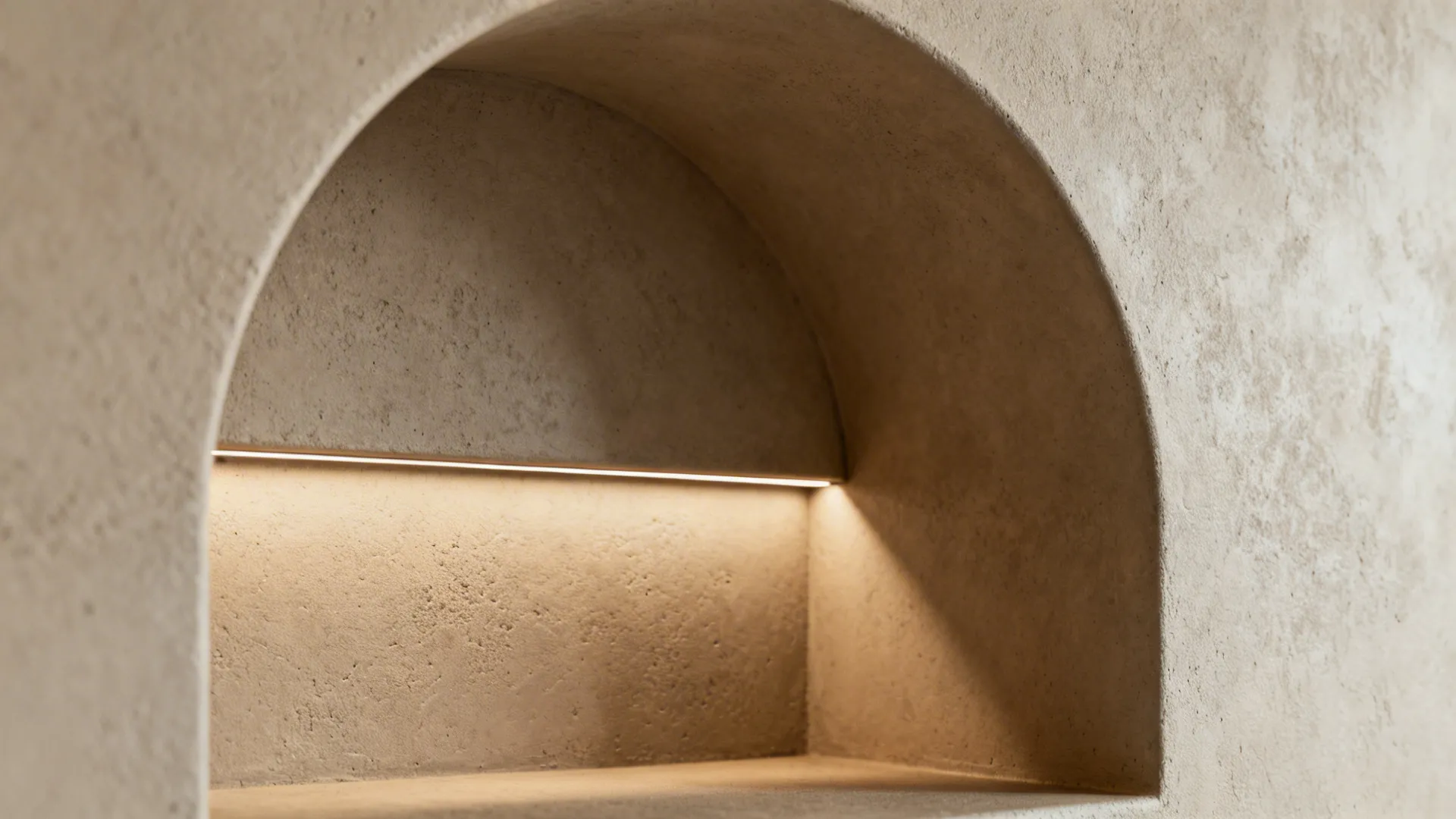 Macro of microcement niche corner with concealed LED grazing the textured surface.