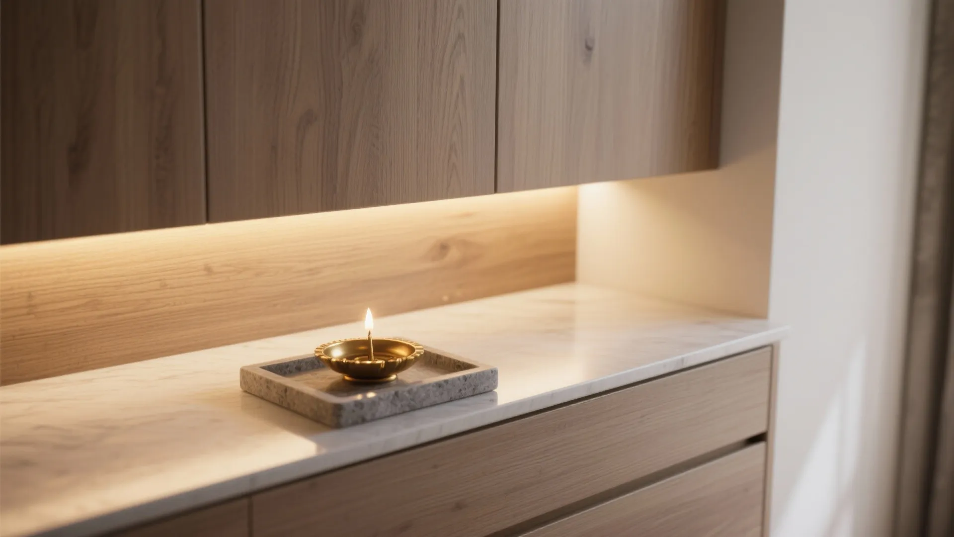 Macro view of warm LED cove light on oak panel with brass diya and stone tray.
