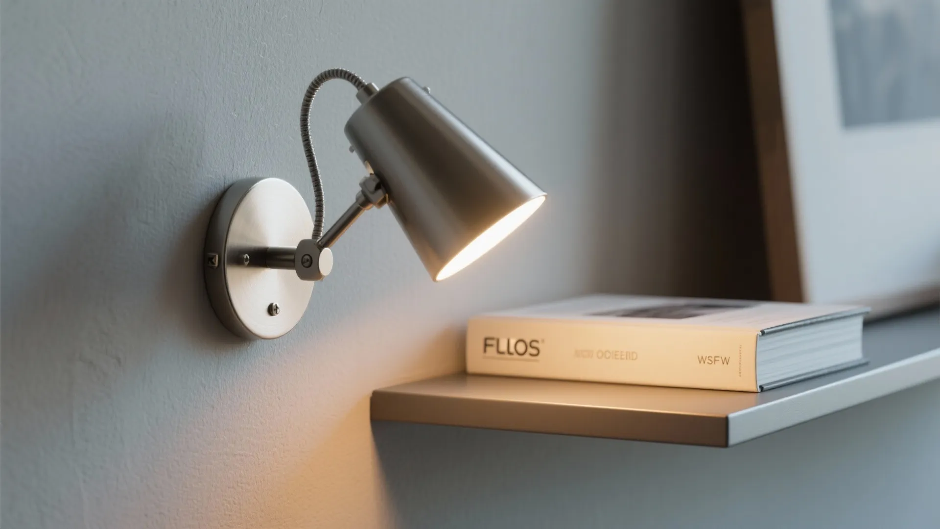 Close-up of Flos wall task light illuminating a book on a slim shelf