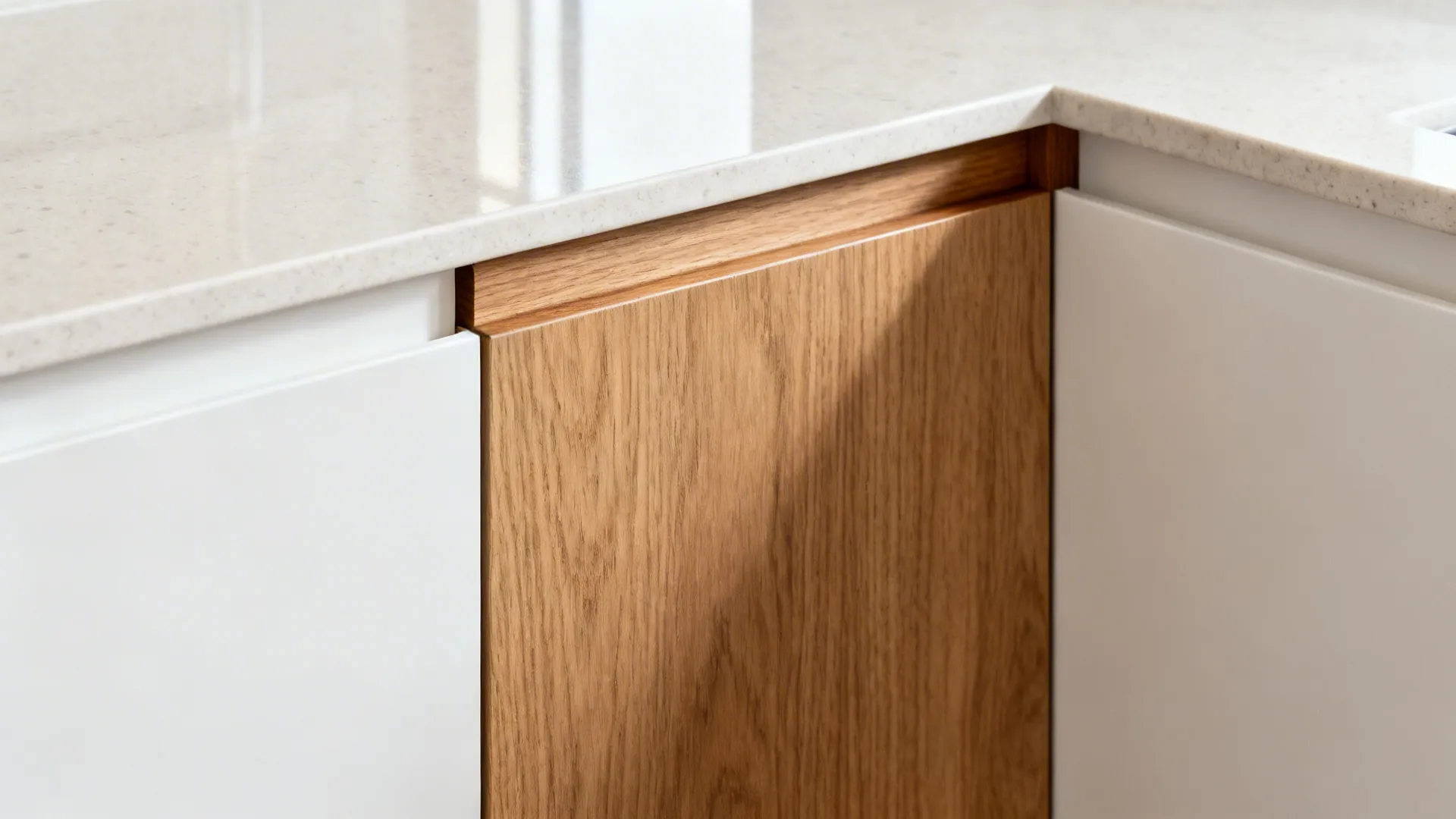 Macro of oak veneer drawer with solid edge-banding beside a white lacquer panel in a kitchen.