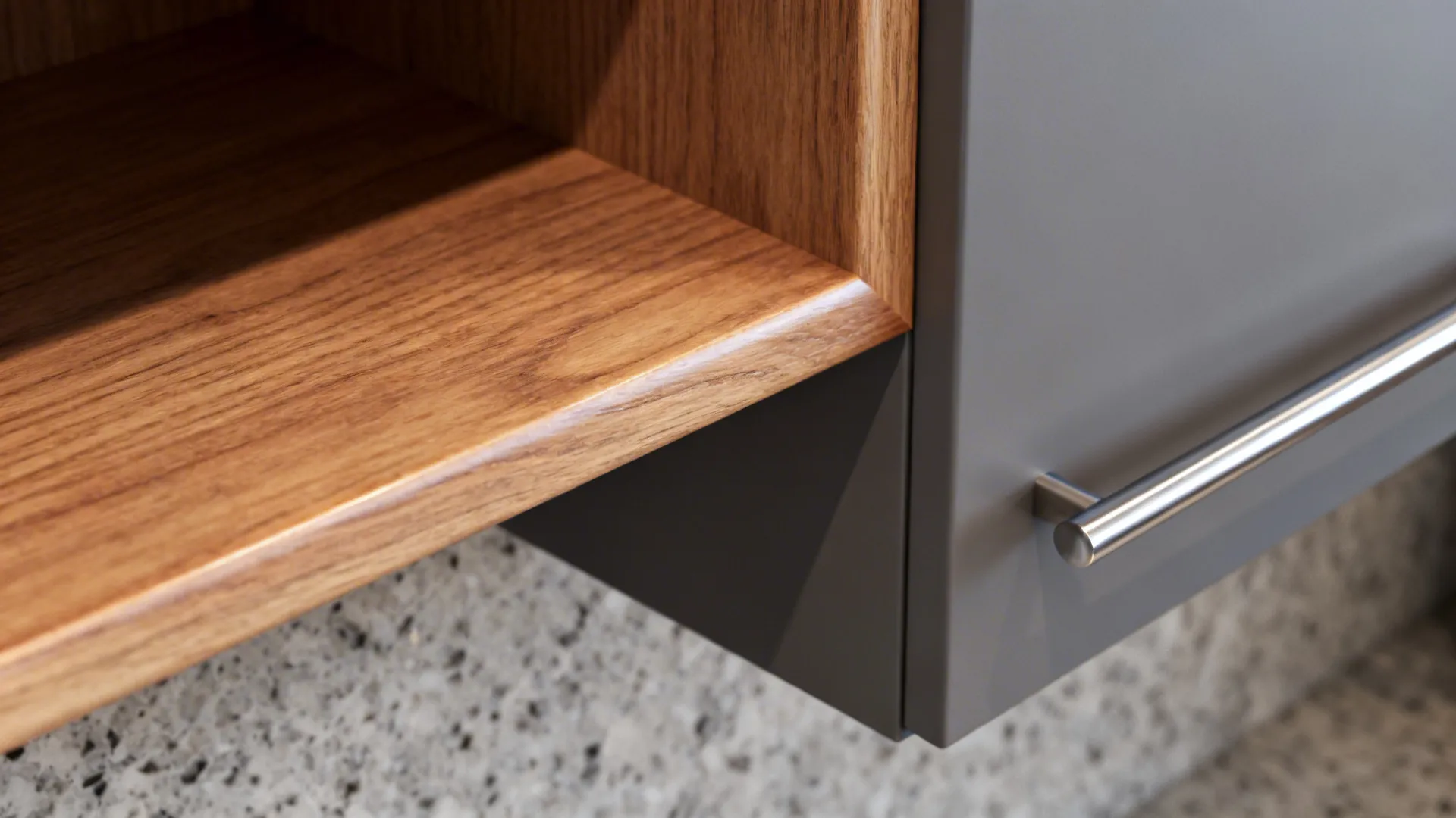 Close-up of an oak open shelf with satin finish above a quartz countertop.