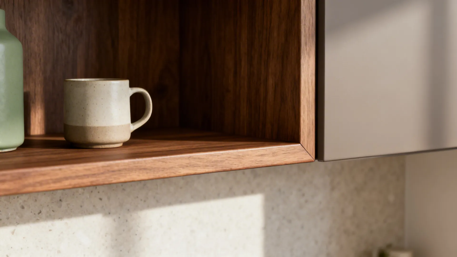 Macro of a mid-tone oak shelf with a ceramic mug against a light quartz backsplash.