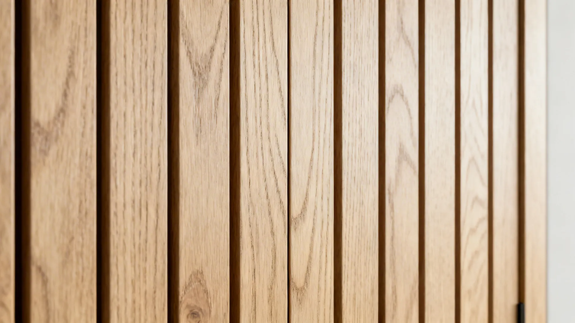 Macro of quarter-sawn white-oak slats with fine reveals and a hidden door seam.