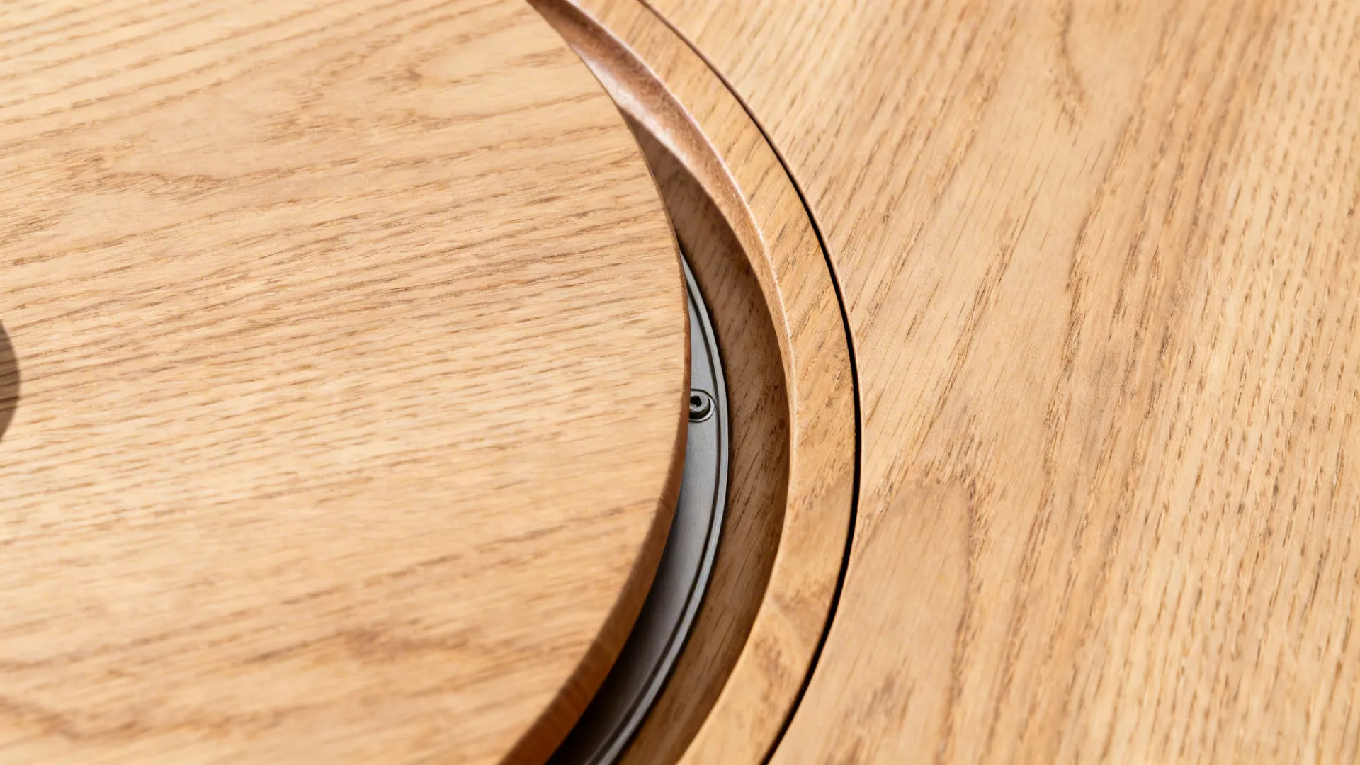 Close up view of wooden table featuring a round built in rotating wood center table part