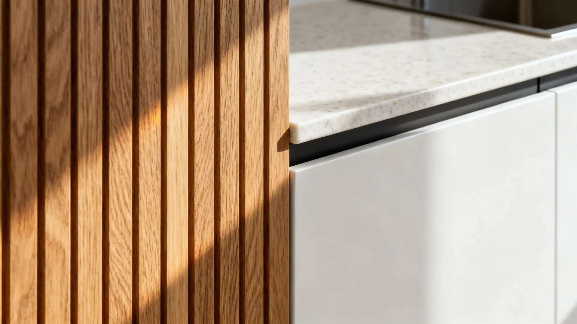 Close-up of rift-cut oak veneer next to matte white cabinet and quartz countertop.