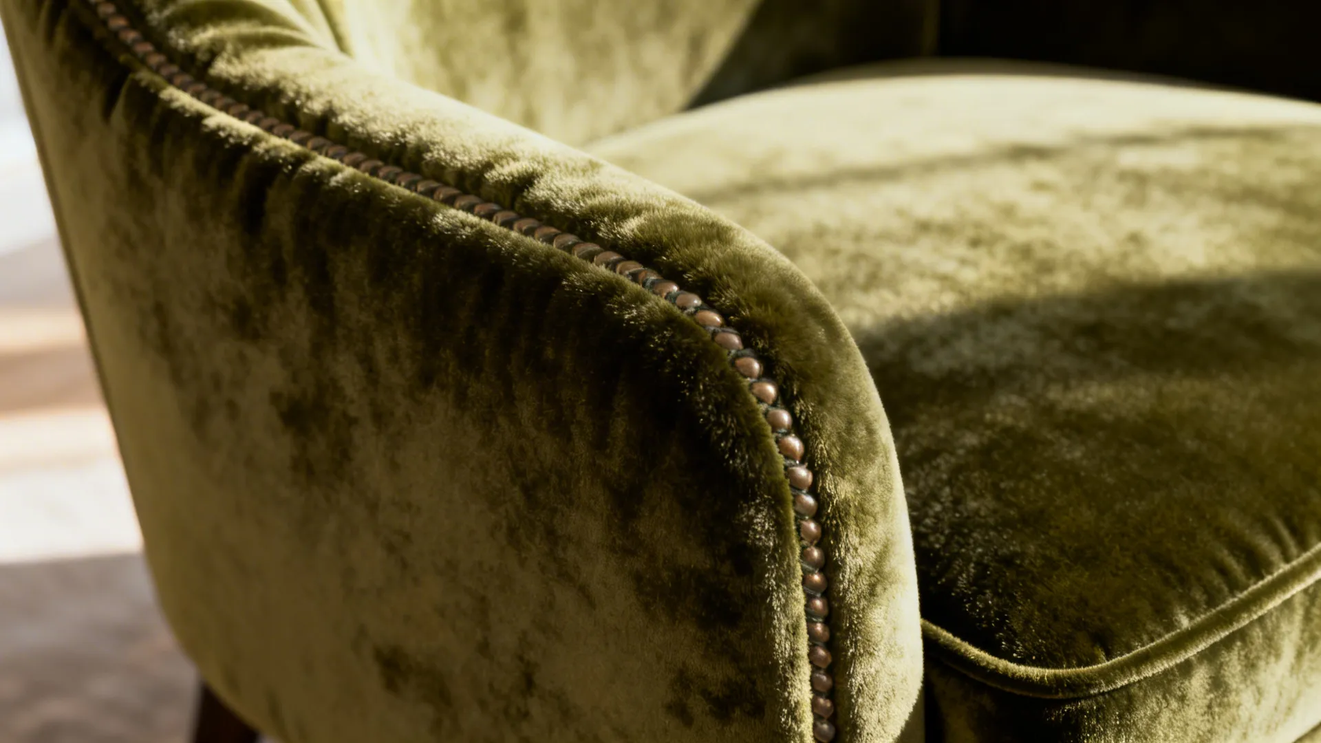 Macro of olive velvet chair showing pile texture and stitching detail