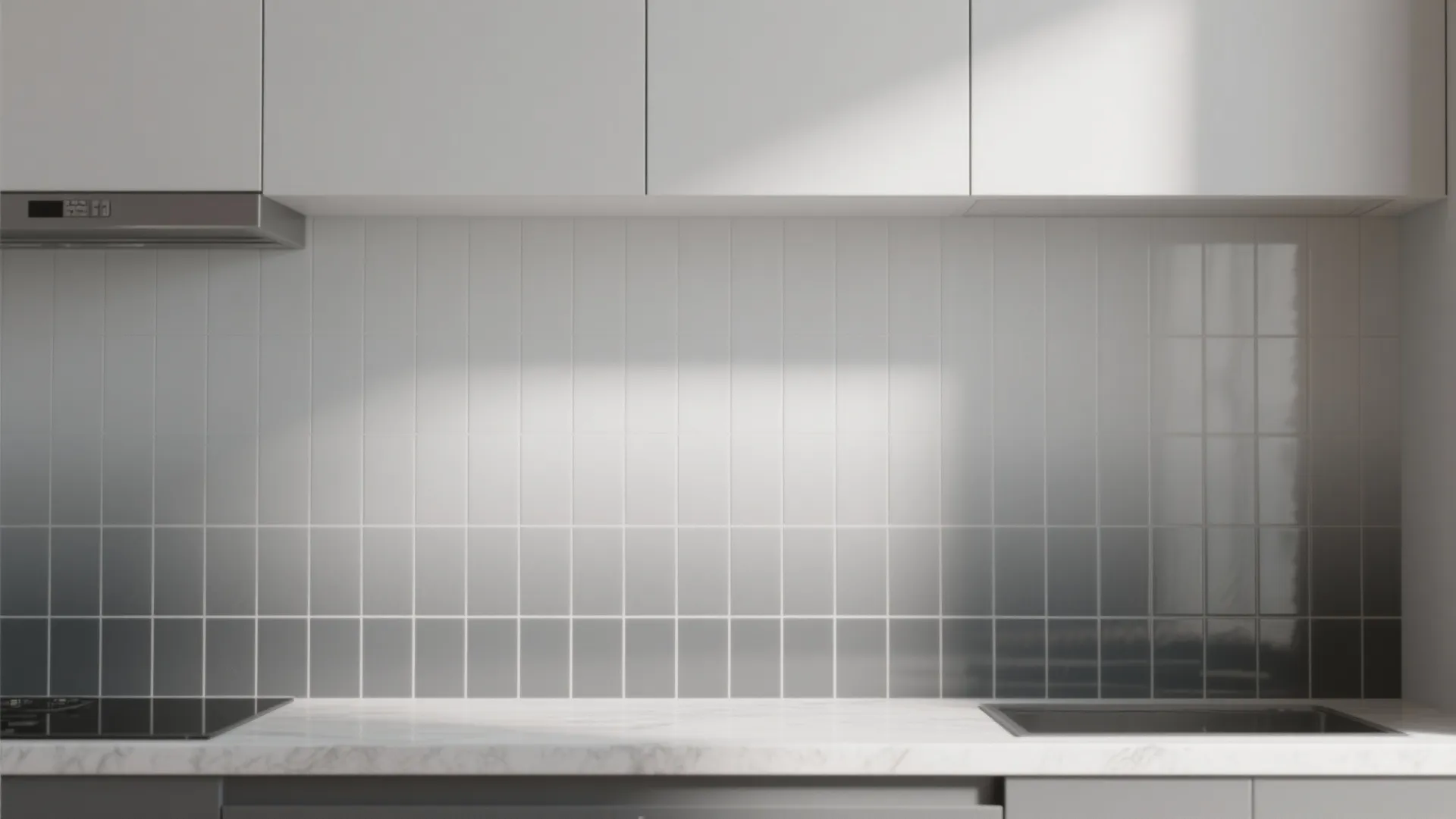 Close up of white wall tiles transition to dark grey above a marble kitchen countertop