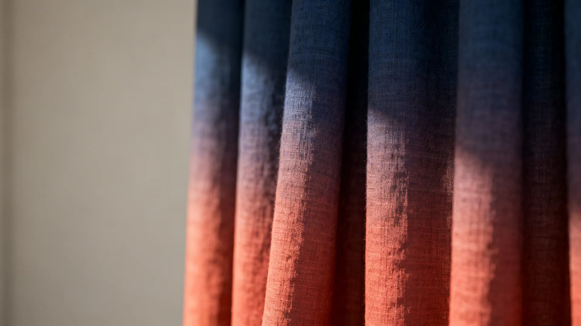 Close up of soft fabric curtain with a color transition from dark blue to bright orange