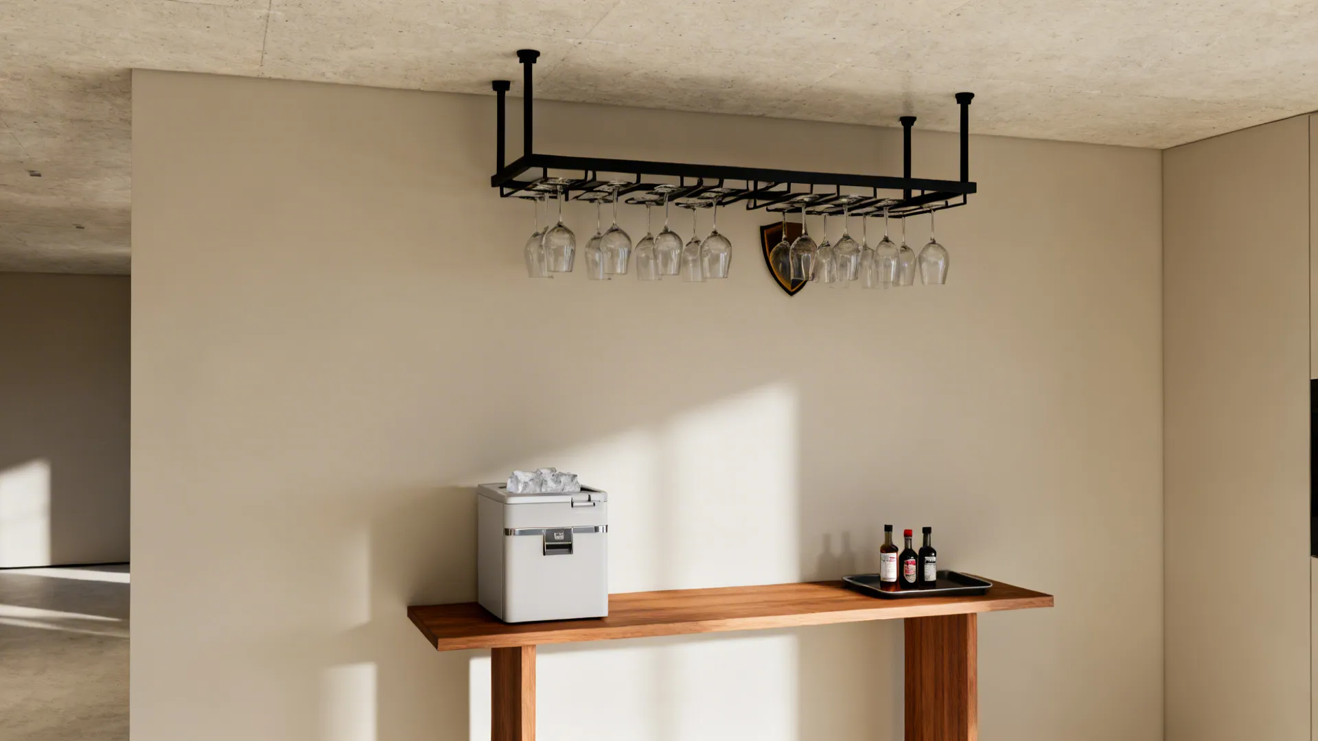 Slim console mini bar with a ceiling-mounted stemware rack against a neutral wall.