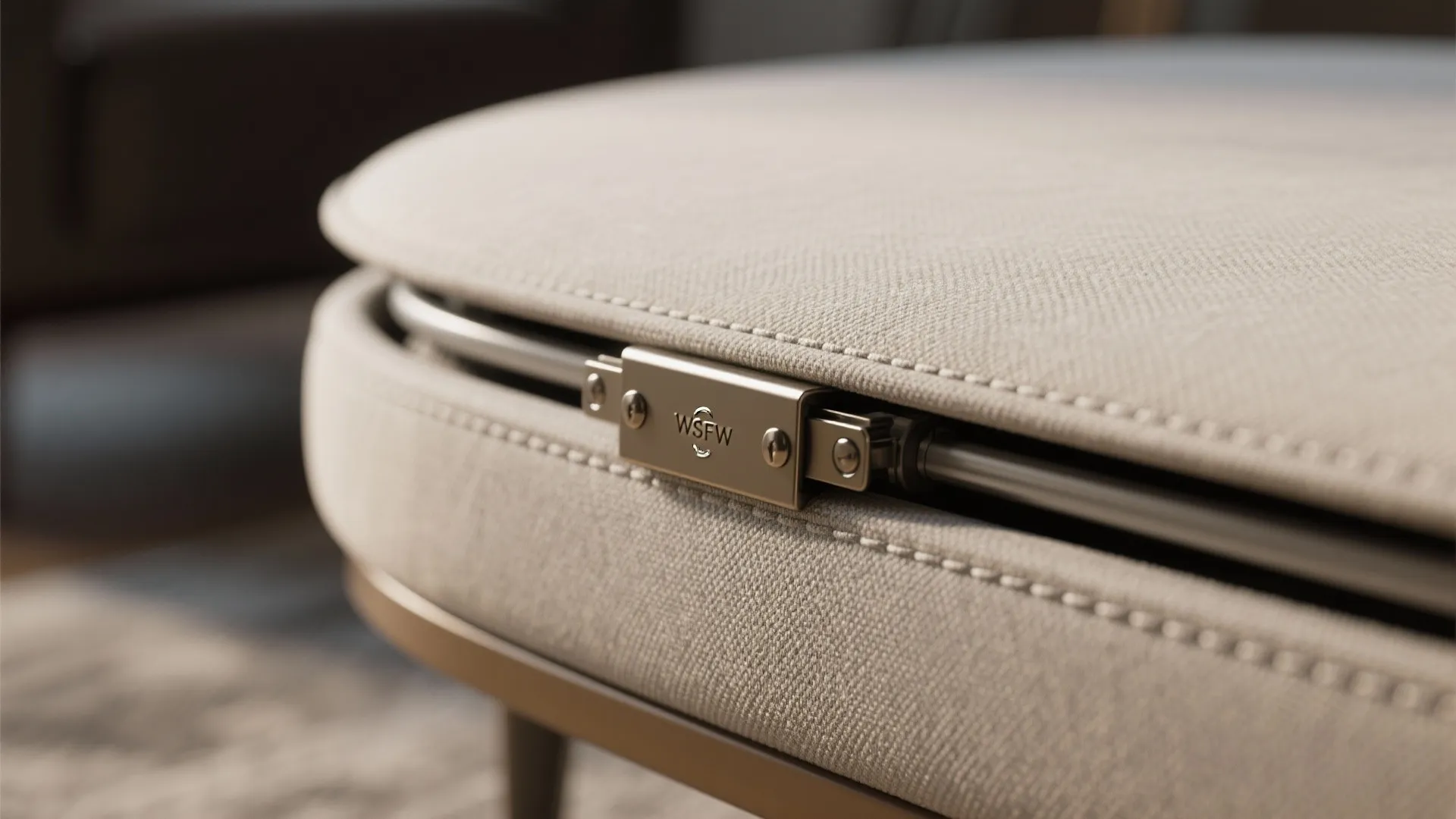 Macro of gas-lift hinge and rounded upholstered edge on a storage ottoman and stool.