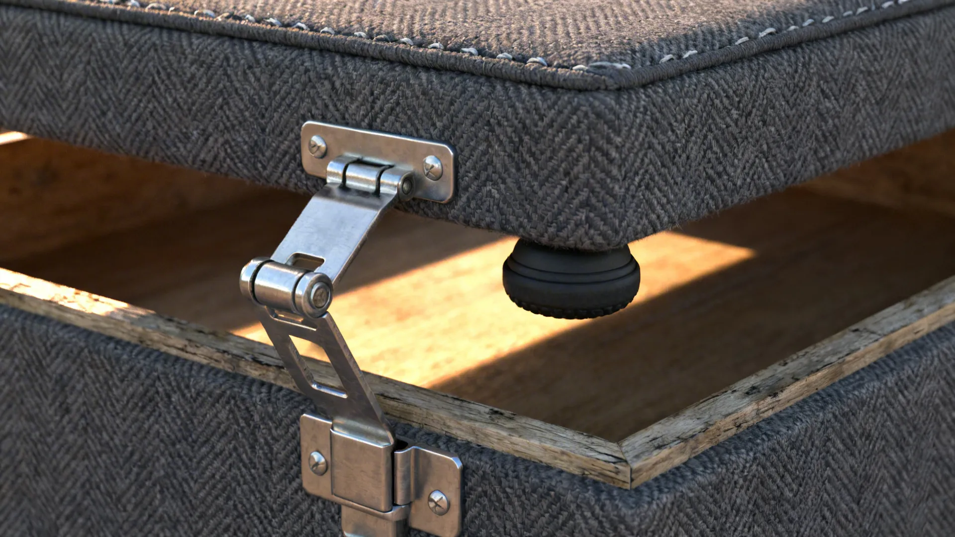 Macro detail of a storage ottoman hinge with upholstered lid and textured fabric.