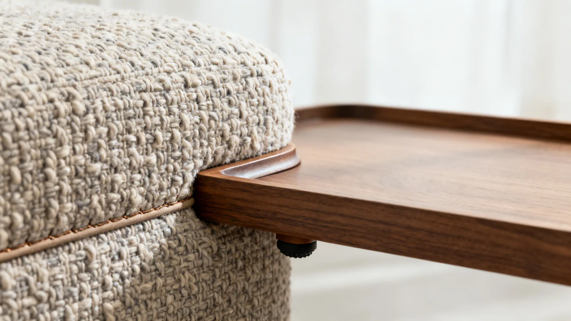 Macro of boucle upholstery meeting a matte oak tray with a lipped edge and rubber feet.