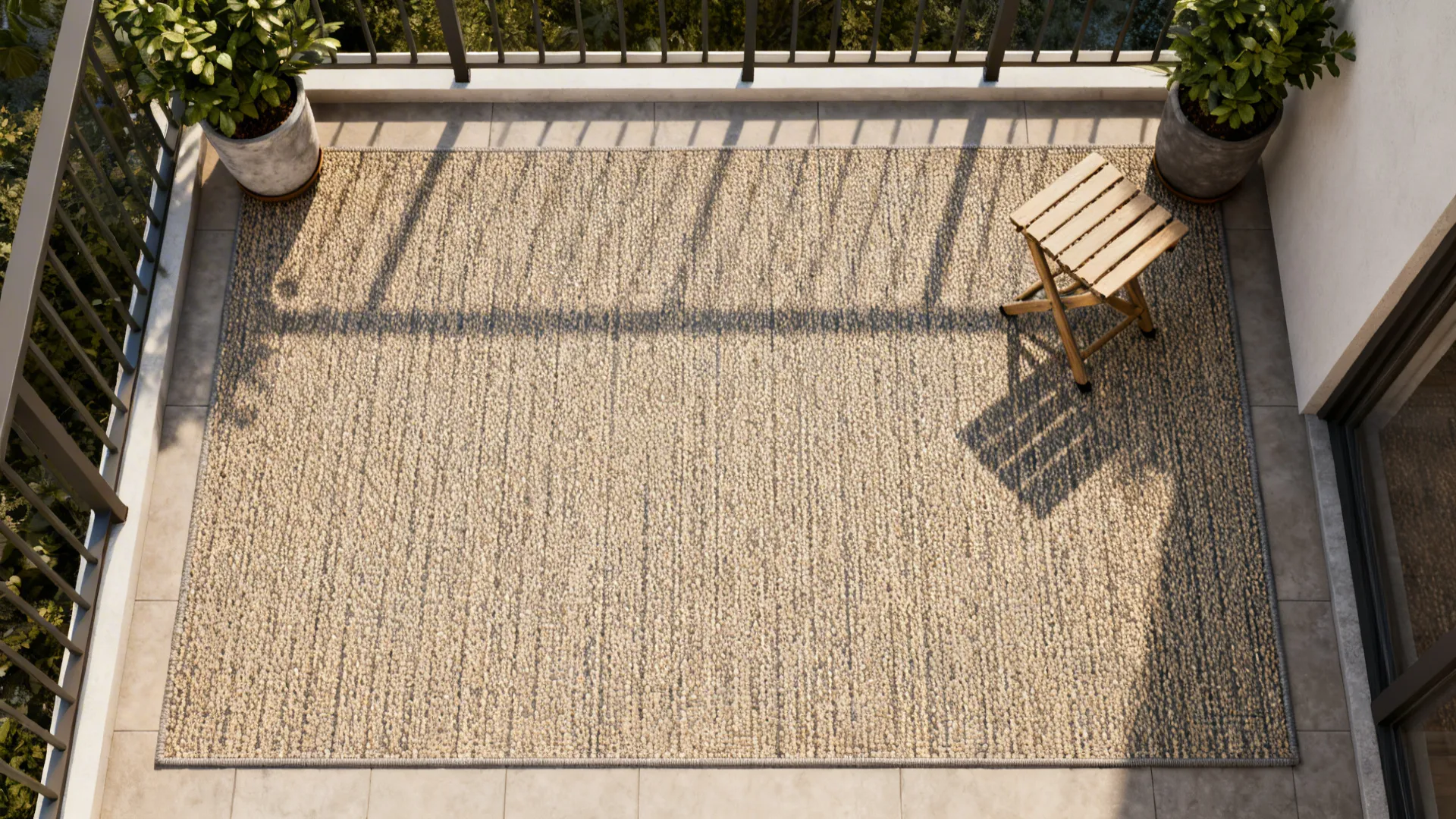 Large woven rug on a balcony floor with a wooden stool and green potted plants
