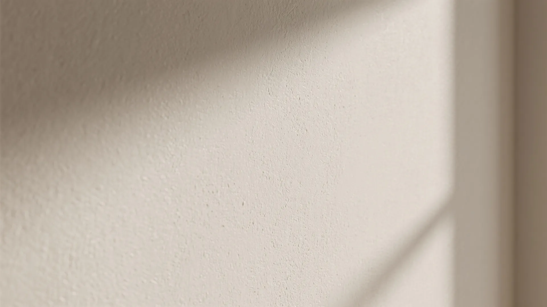 Close up of neutral textured wall paint with soft shadows and clean indoor lighting effect