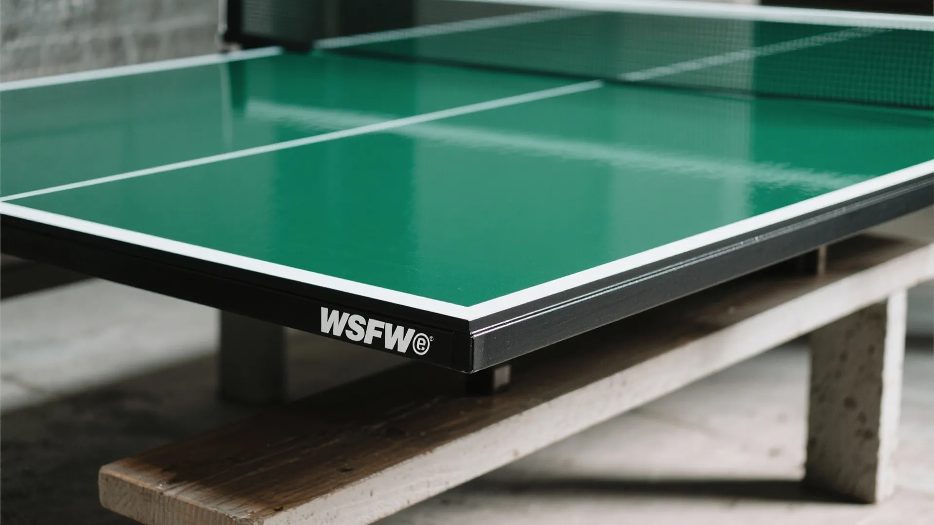 Close up view of a green table top surface with white lines and black edge