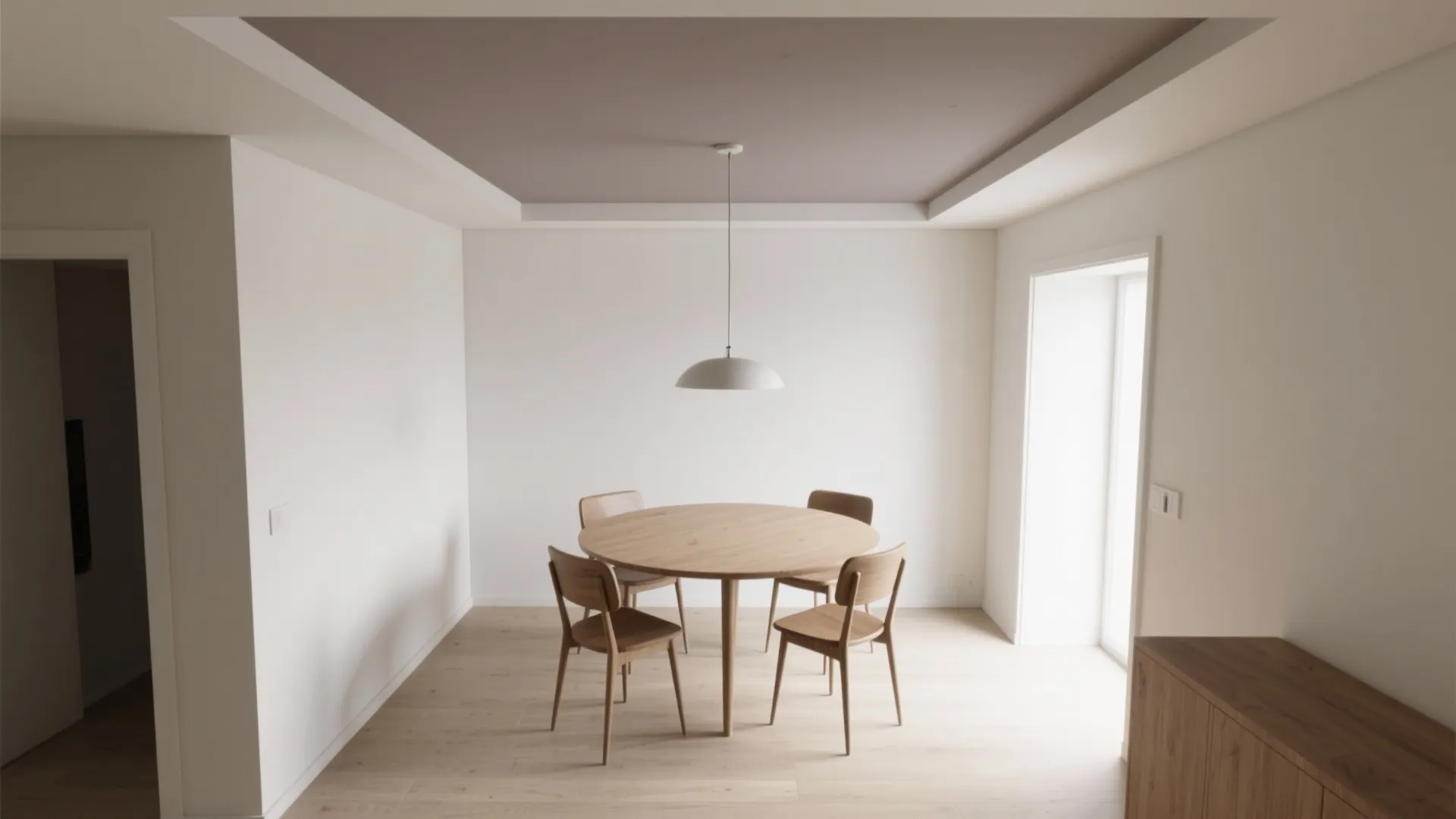 Minimalist dining area featuring a round wooden table with four chairs and a ceiling light