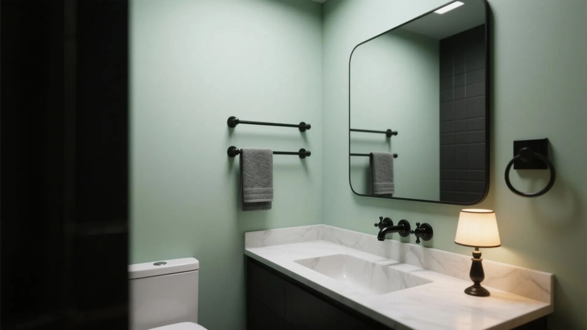 Modern green bathroom featuring a white marble sink black faucet large mirror and small lamp