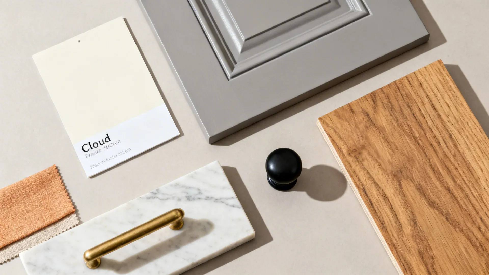 Ivory, gray, oak, marble-look quartz, brass, and black hardware flat lay.