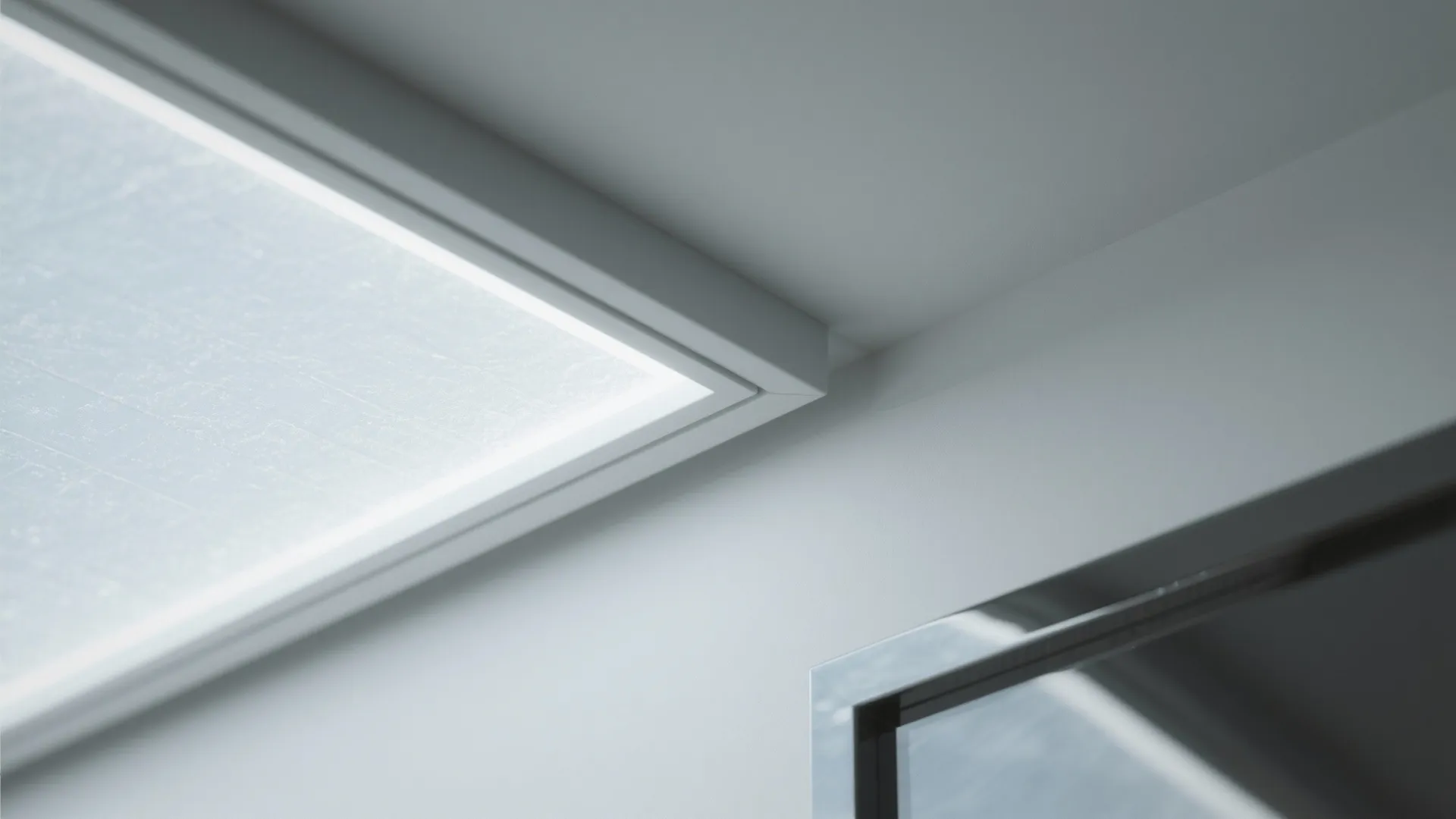 Close up of rectangular white ceiling light panel next to a silver metal window frame