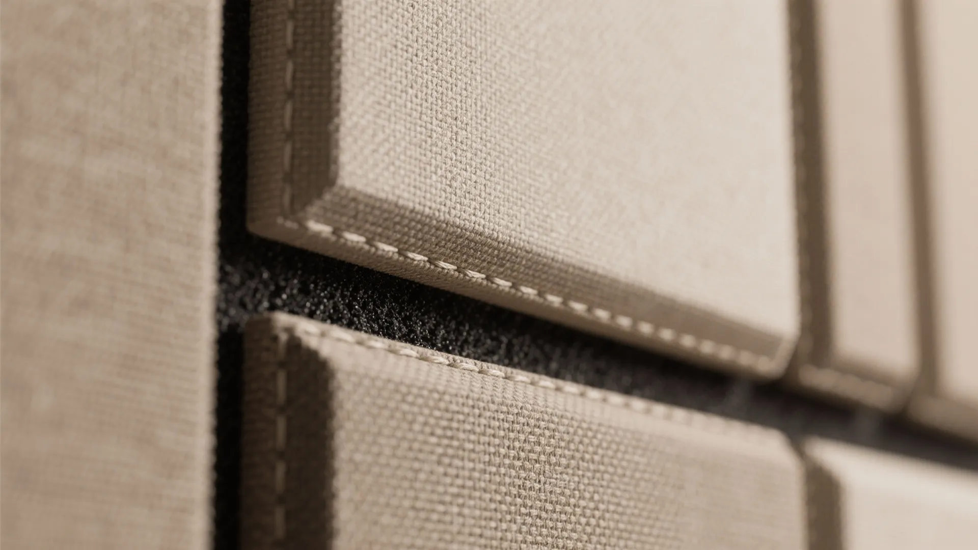 Close up view of beige fabric wall panel design with visible stitches and textured soft surface