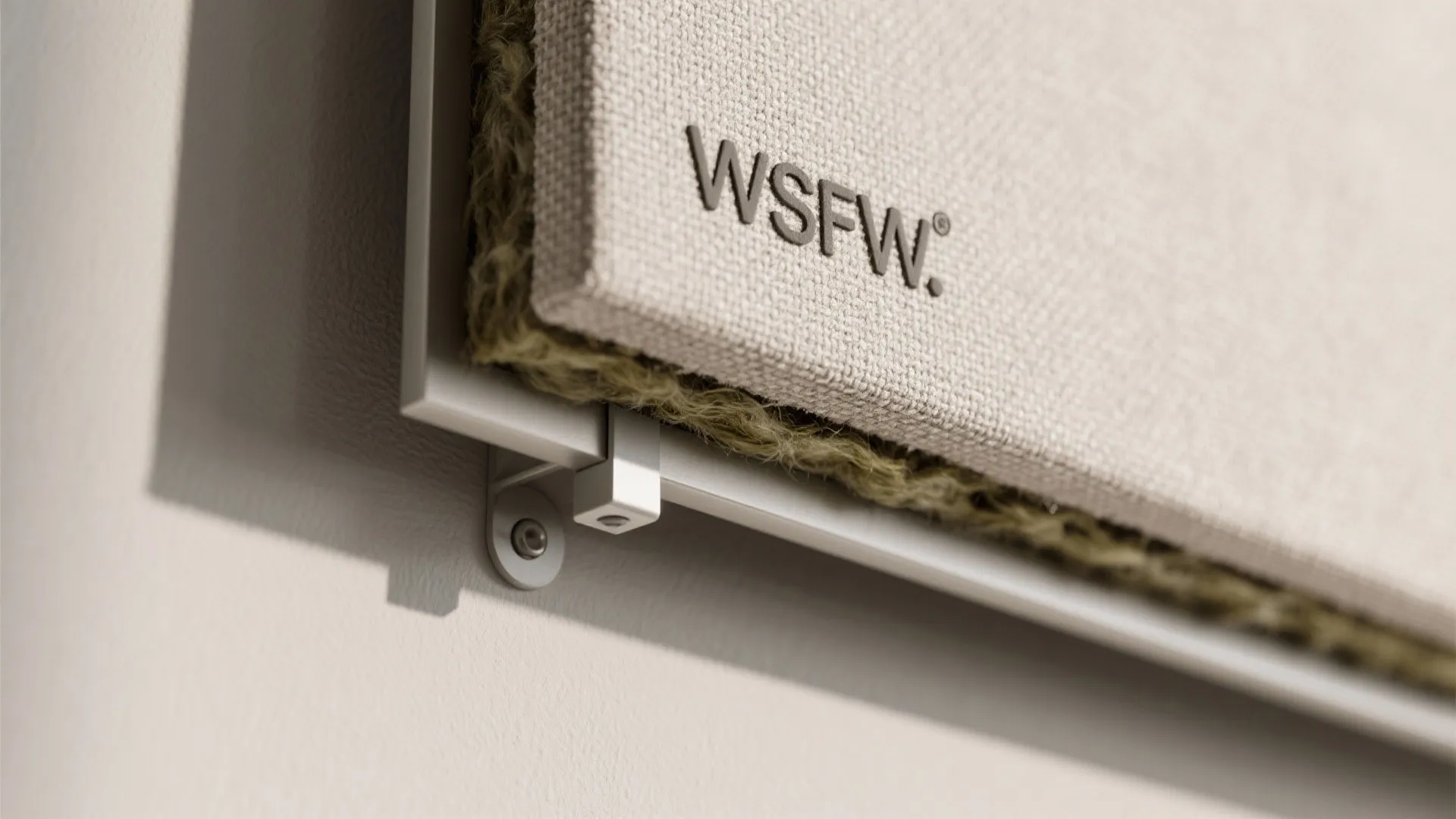 Macro close-up of acoustic panel fabric and air gap standoff detail on a small studio wall.