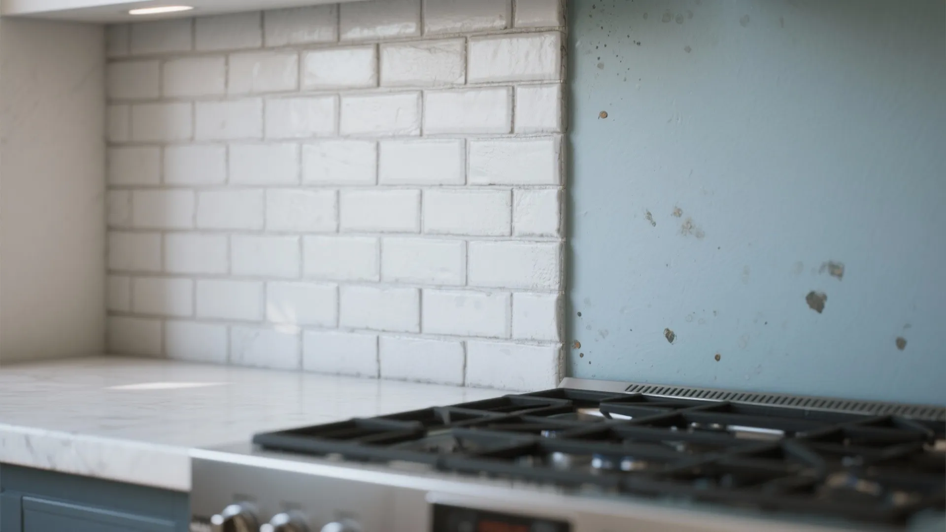 Modern kitchen with white brick wall tiles next to blue wall and black stove top