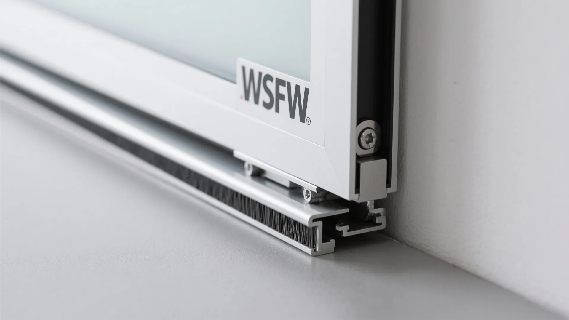 Close up shot of a sliding door bottom track with brush seal and silver metal frame
