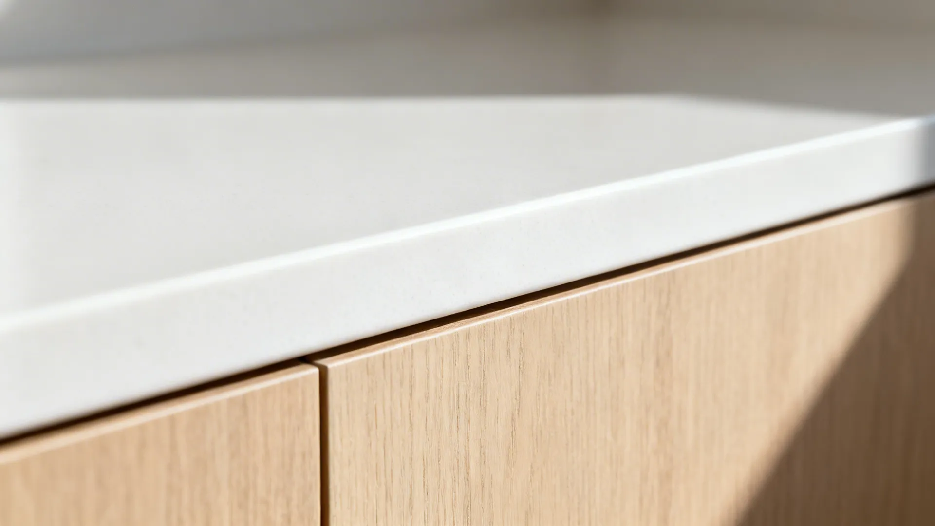 Macro view of a white quartz and oak pass-through ledge with crisp detailing in soft light.