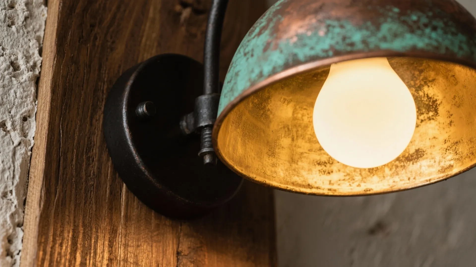 Macro of tarnished brass, verdigris copper and matte black iron finishes reflecting warm light.