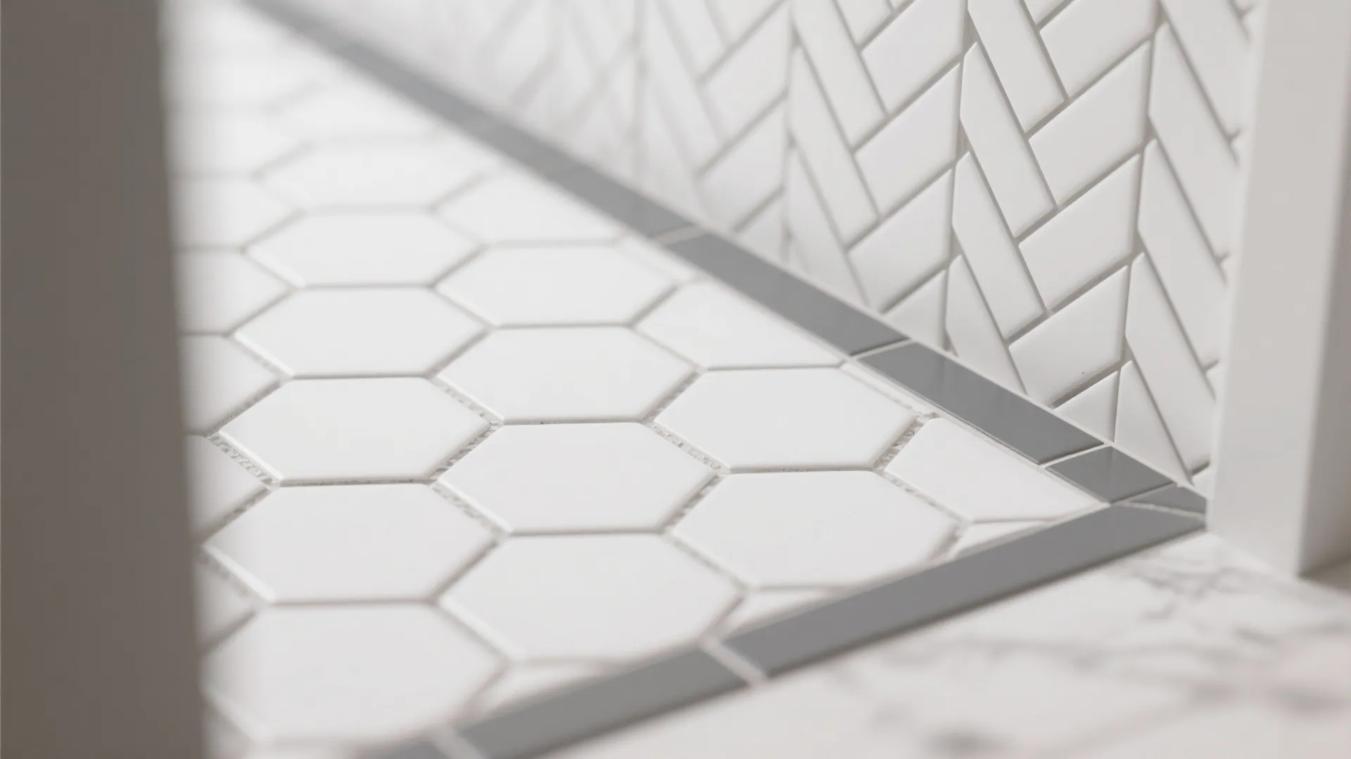 Macro of white hex floor with gray border and crisp grout near a herringbone wall.