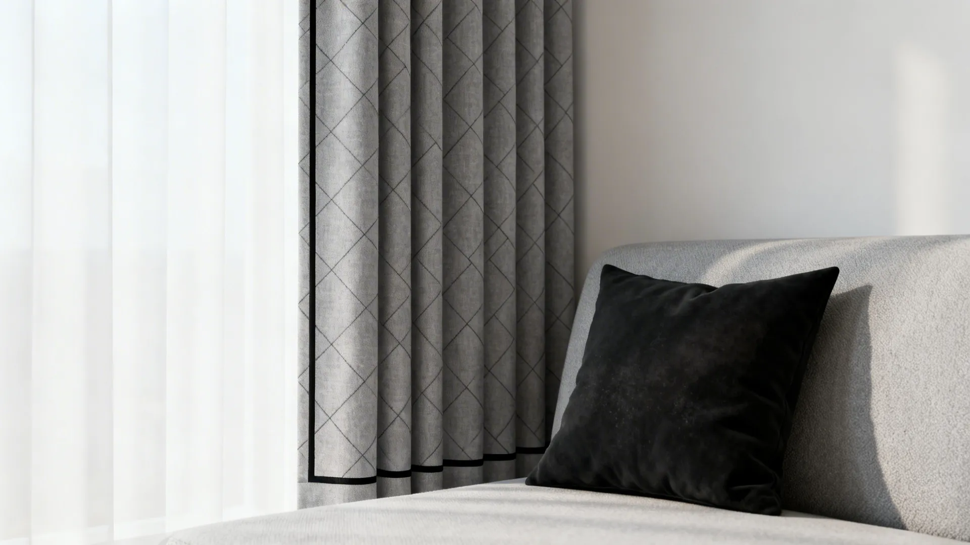 Grey diamond pattern curtain hanging by a window next to a sofa with black pillow