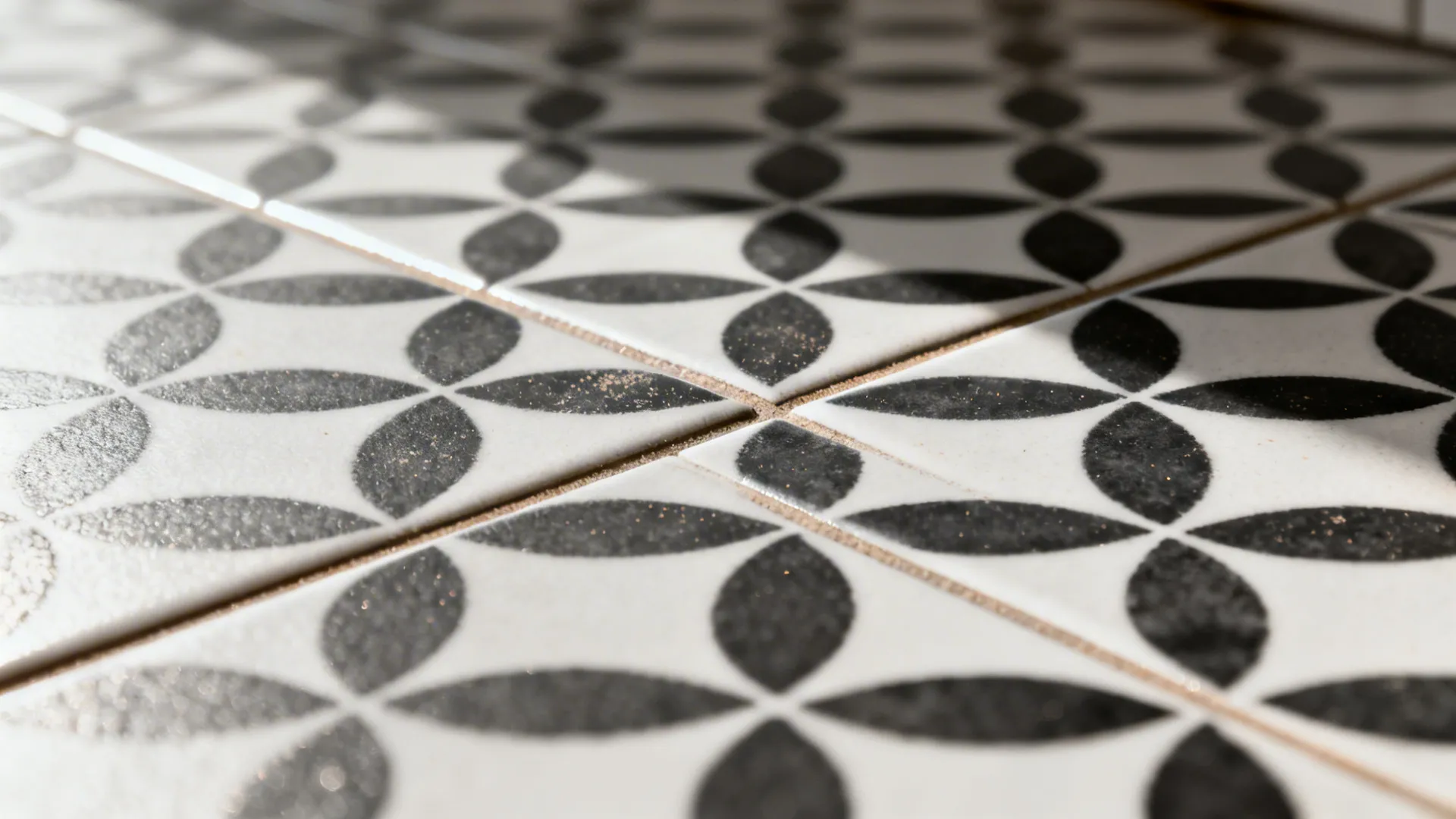 Macro of patterned porcelain floor showing tight grout and matte texture in a black-and-white motif.