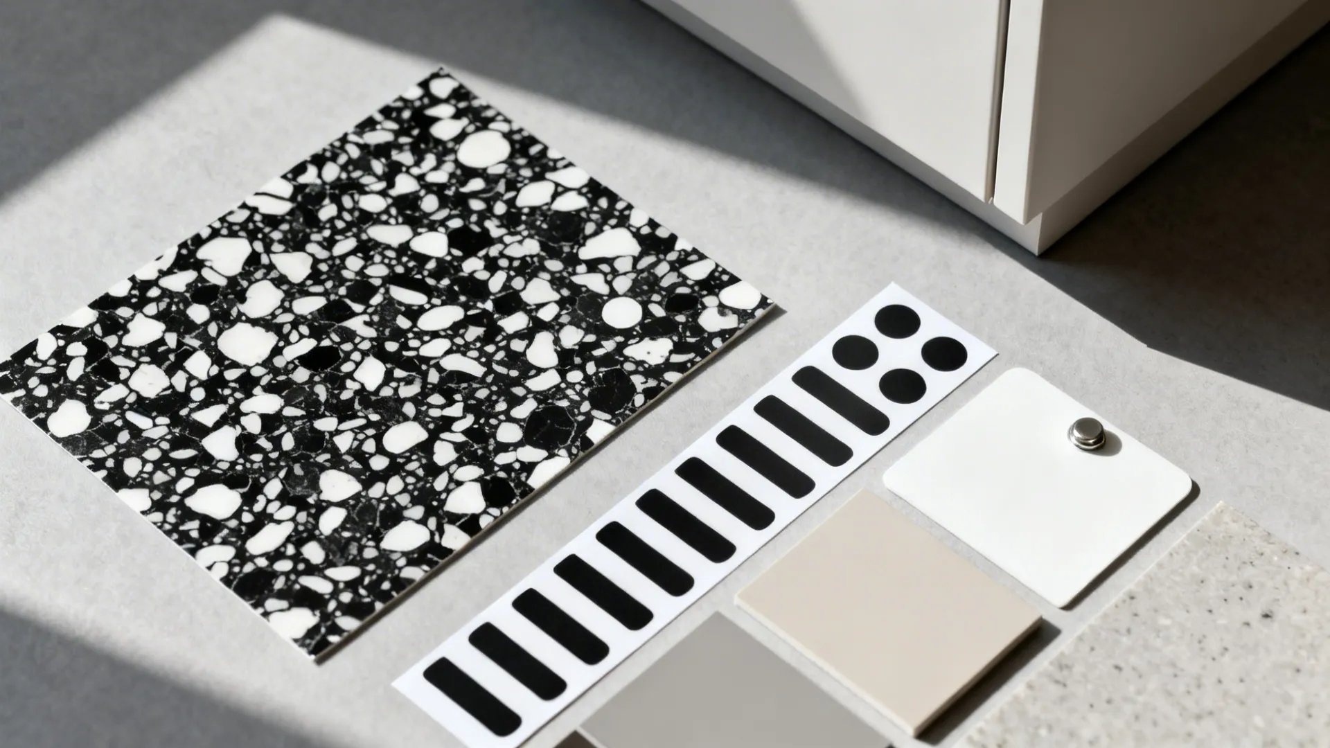 Flat lay of terrazzo vinyl, pattern decal samples, magnet sheet, and neutral finish chips.