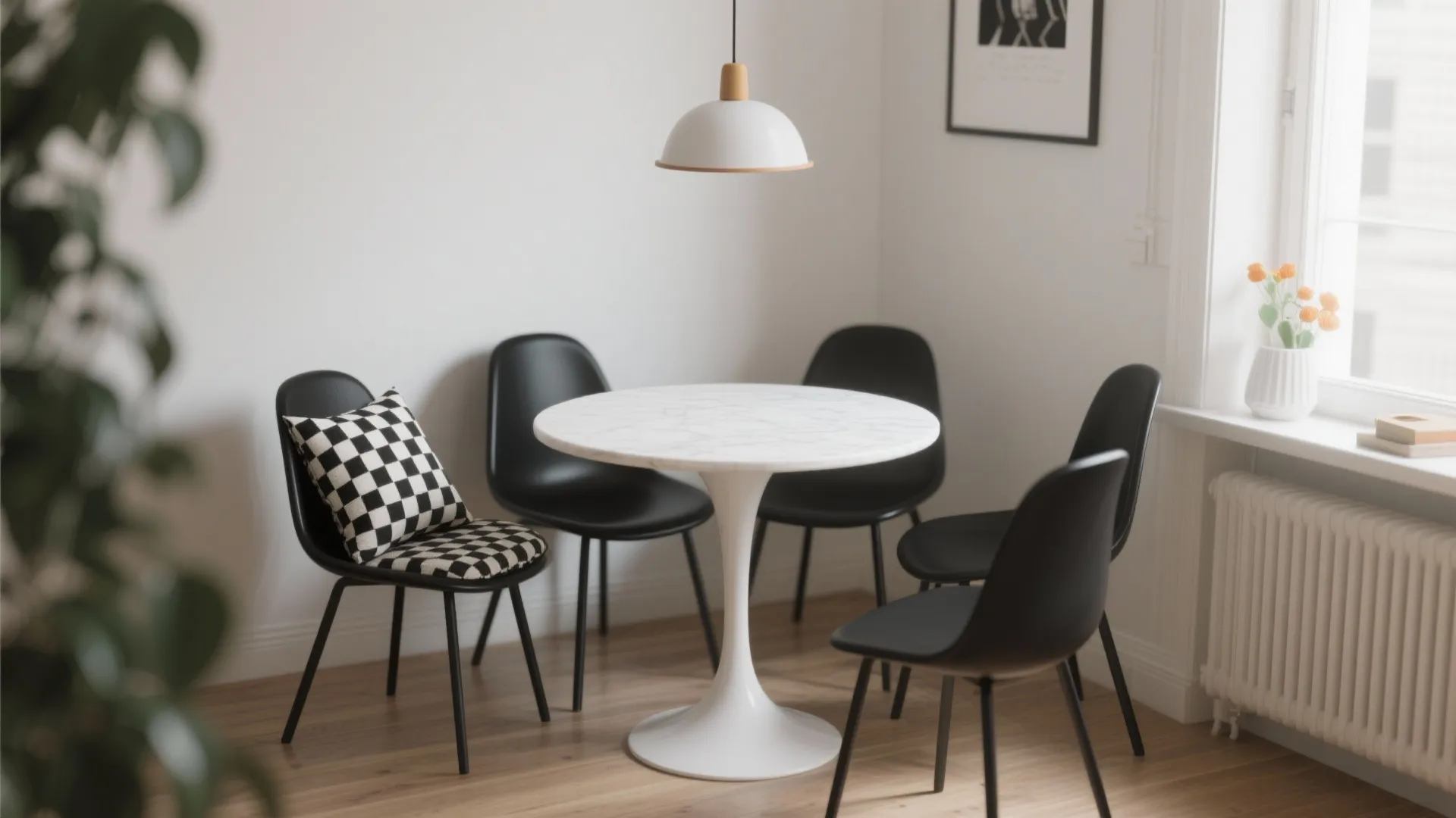Small dining area with black and white chairs and one patterned accent cushion