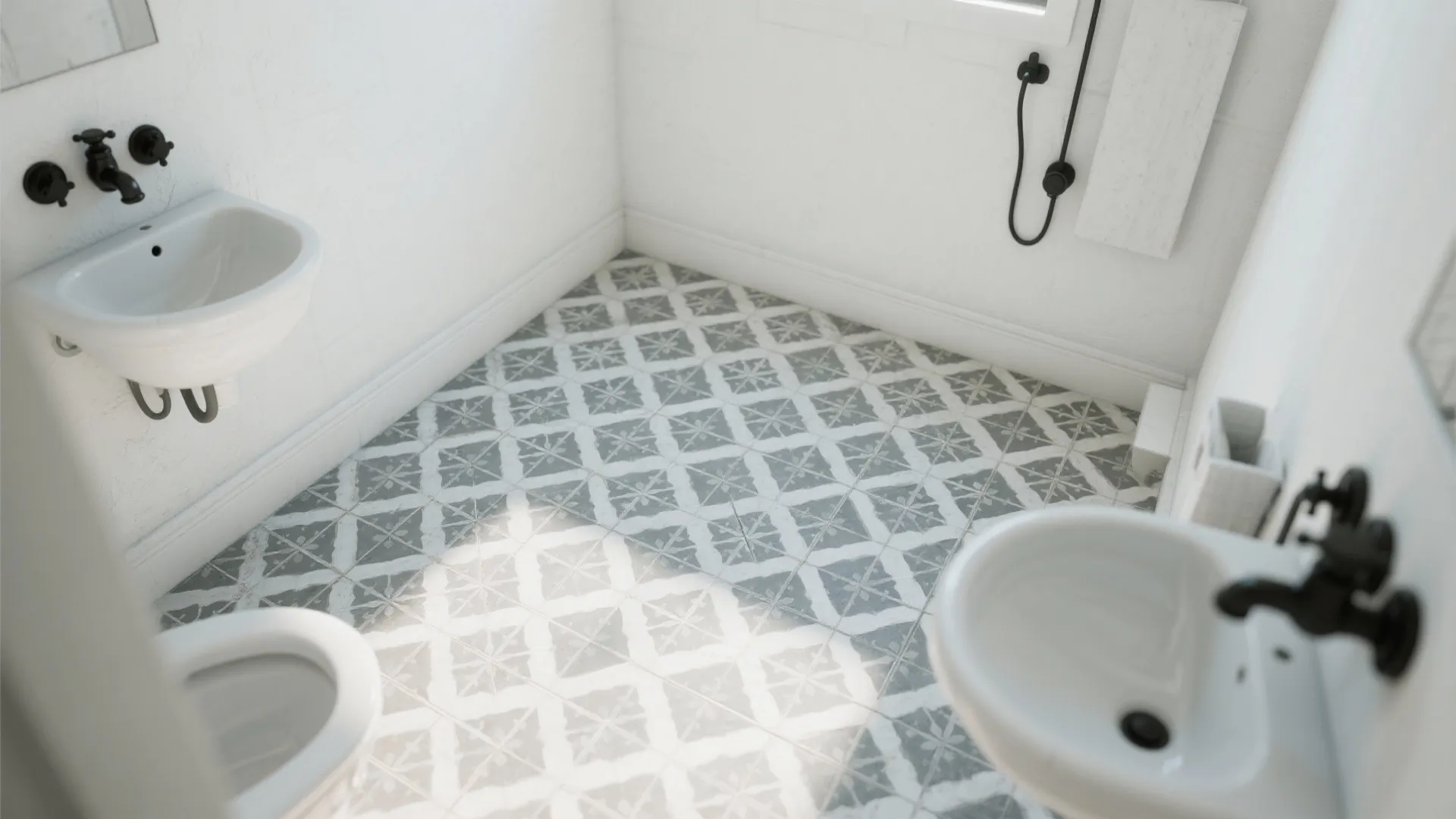 Top view of bathroom with patterned gray floor tiles white toilet small sink and black faucets
