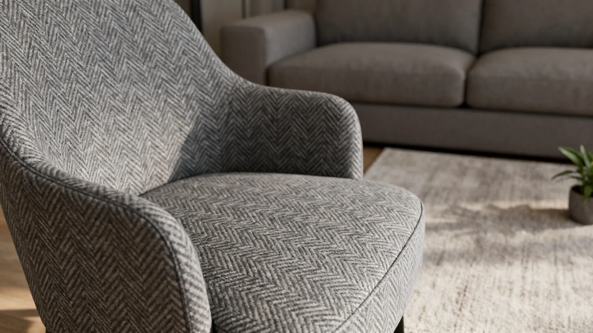 Grey accent chair with subtle herringbone pattern paired with a neutral sofa.