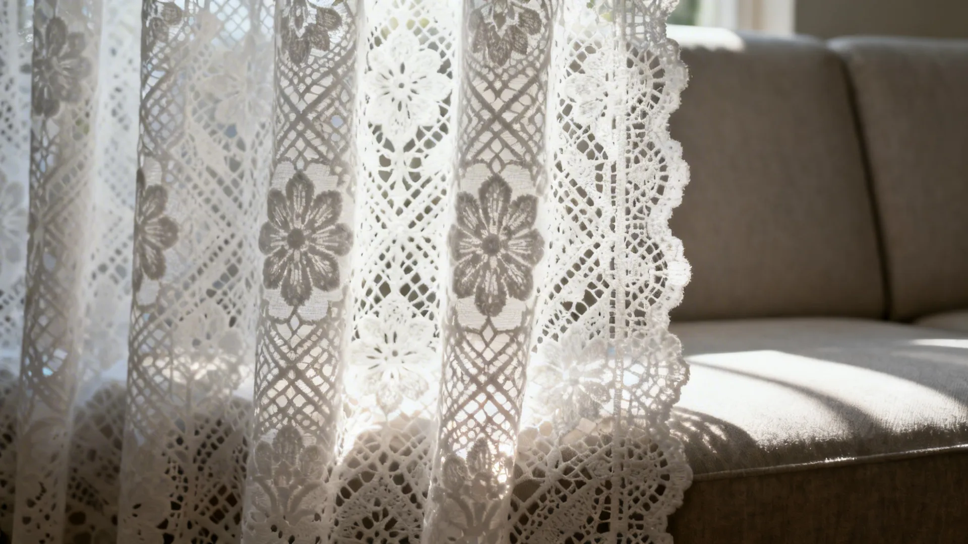 Backlit patterned white lace curtain with visible floral and geometric motifs.